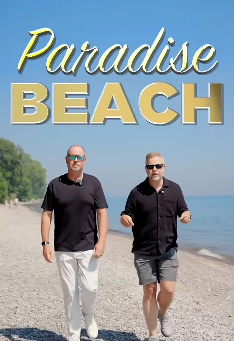 Two men in dark shirts walk along a rocky beach under a clear sky with the words "Paradise Beach" in bold letters above them.